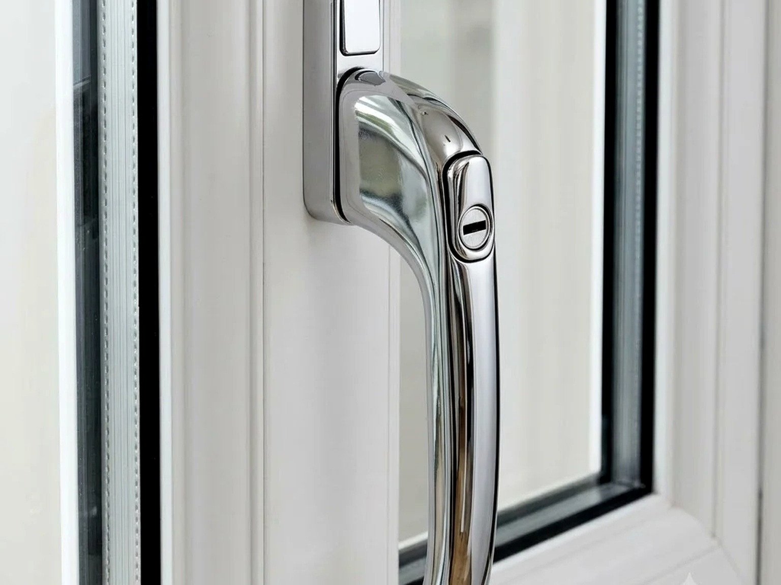 Chrome window handle fitted to a white uPVC frame